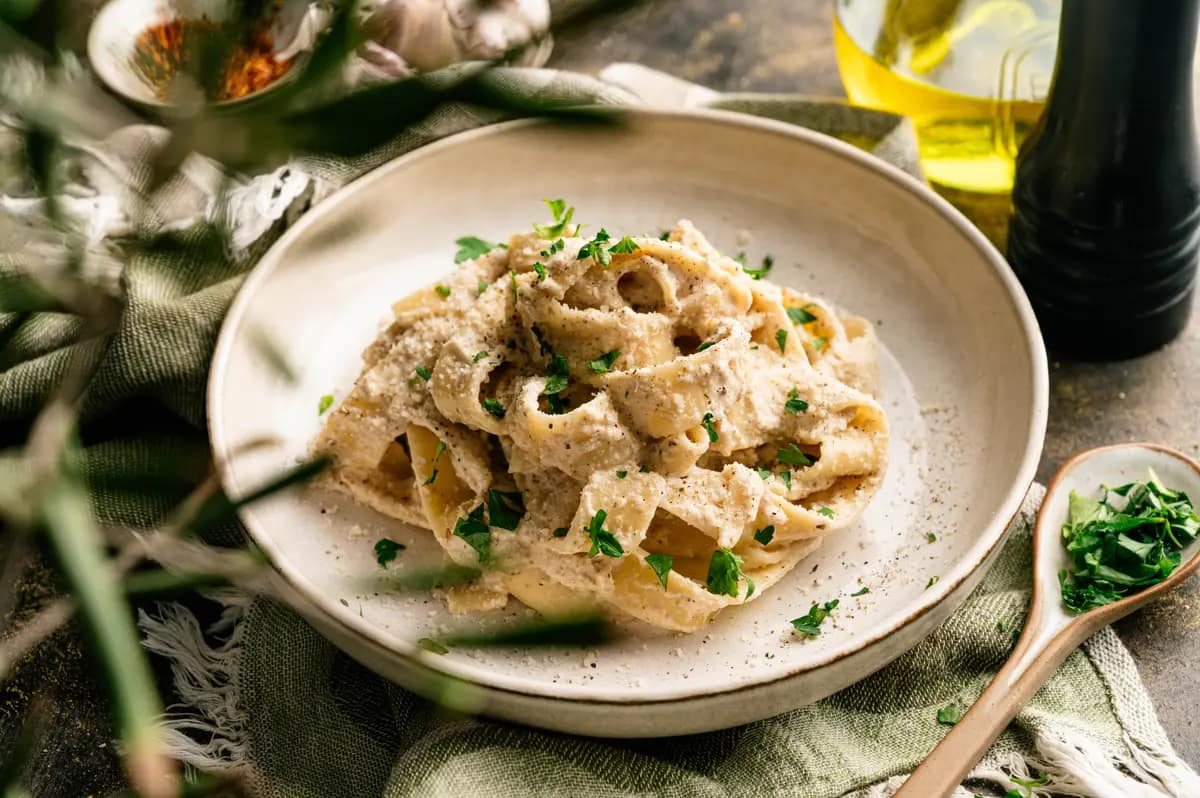 Salsa di Noci pasta served on a pale ceramic plate with creamy walnut sauce.